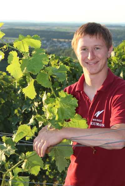 Steffen Neumann lehnt am Rebdraht im Weinberg