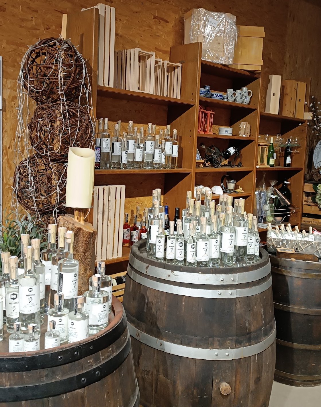 Flaschen auf Holzfässern und Regale im Hofladen